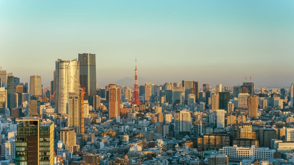 Golden-hour skyline of Minato, Tokyo, with Tokyo Tower rising among the high-rise towers
