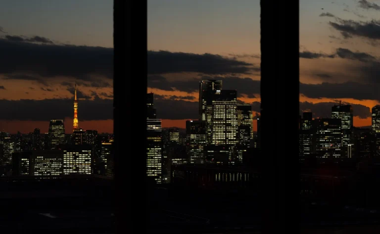 Tokyo skyline at dusk with Tokyo Tower seen between two dark pillars from Aman Tokyo