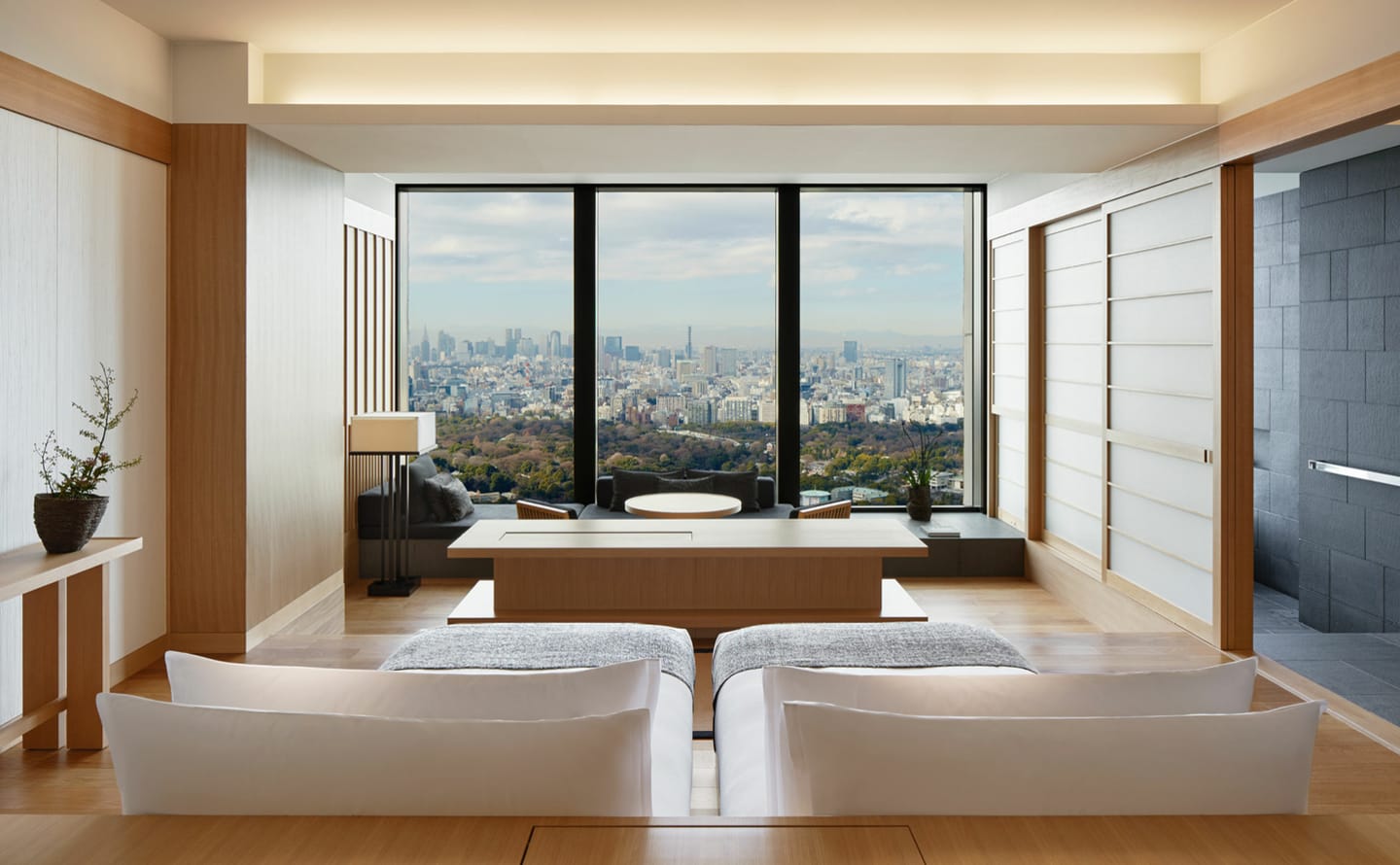 Suite living area at Aman Tokyo with floor-to-ceiling windows overlooking the city and the Imperial Palace gardens